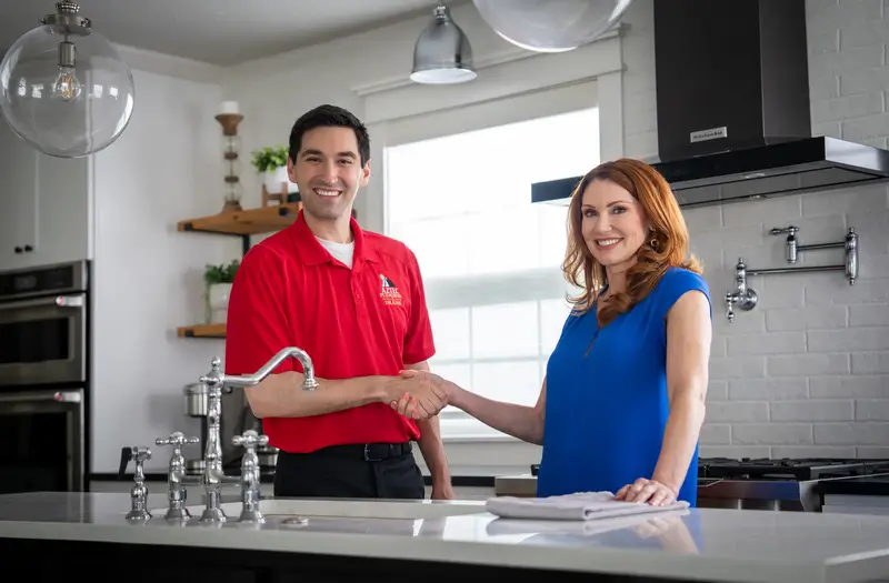 Aztec Plumbing technician smiling while talking with customer