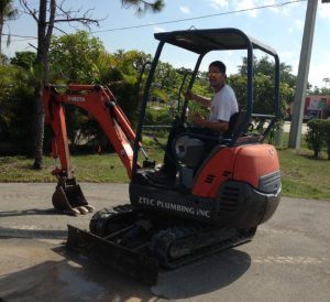 Aztec plumber in a small excavator